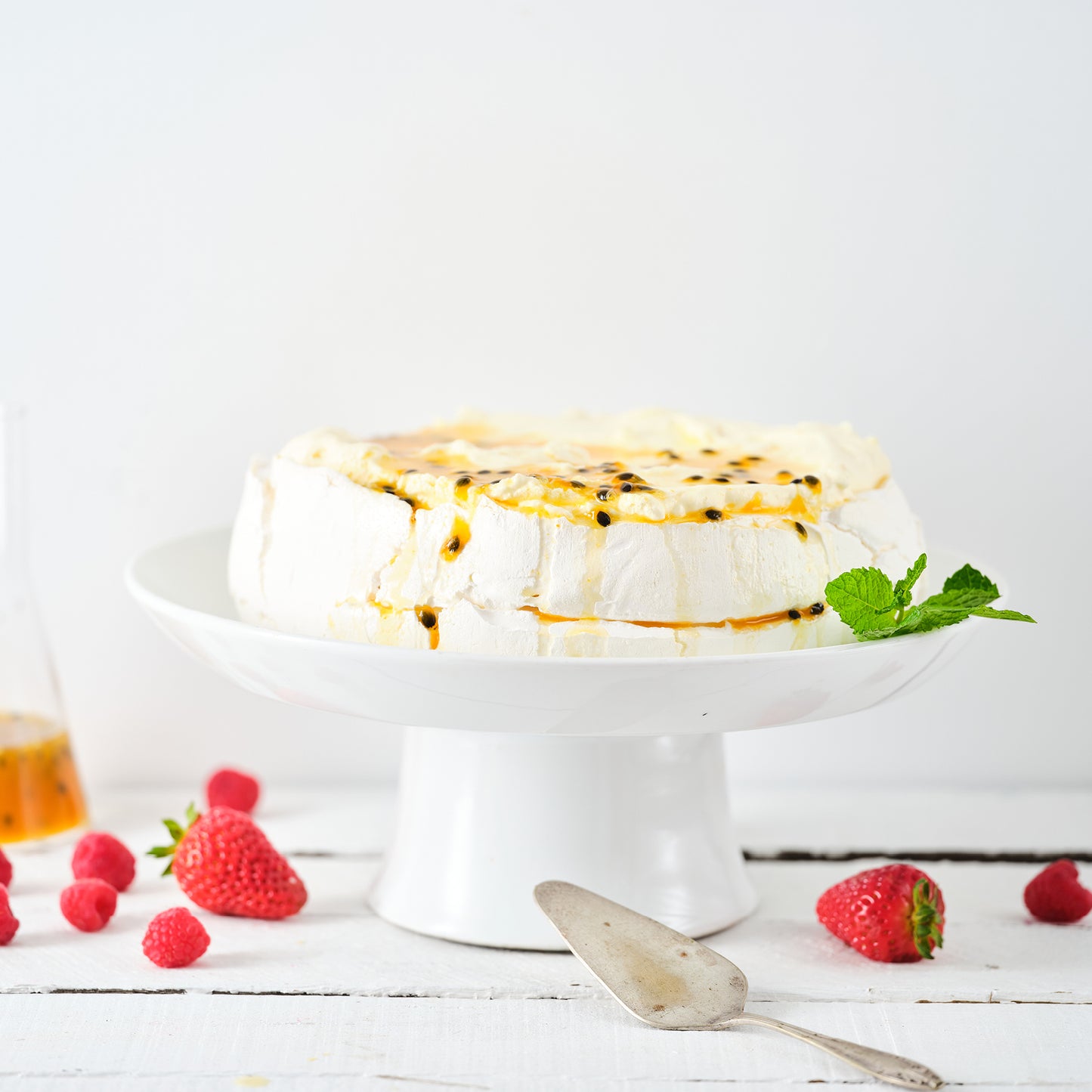 PAVLOVA, BERRIES, WHIPPED CREAM, PASSIONFRUIT SAUCE.